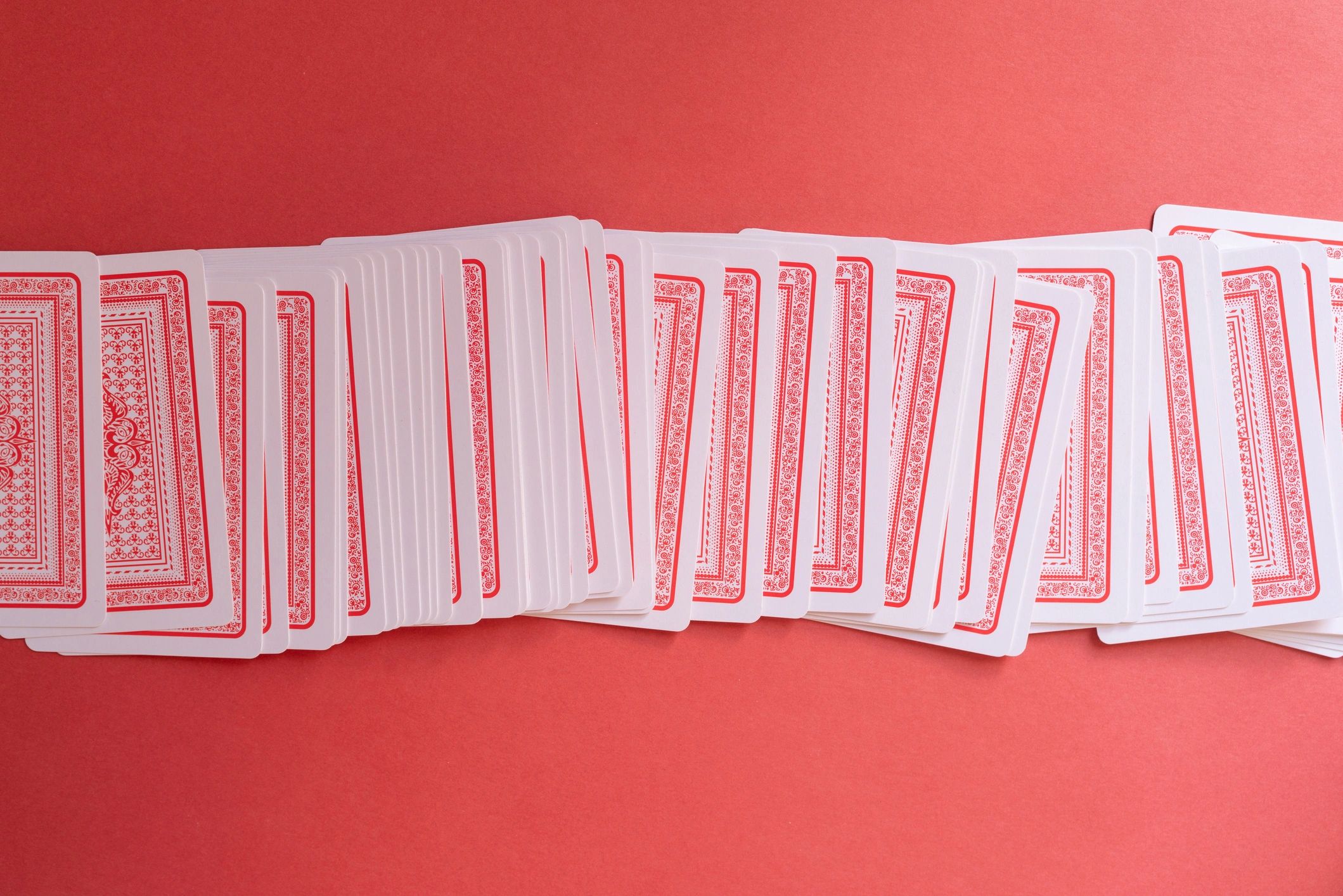 Shuffled playing cards on a red background