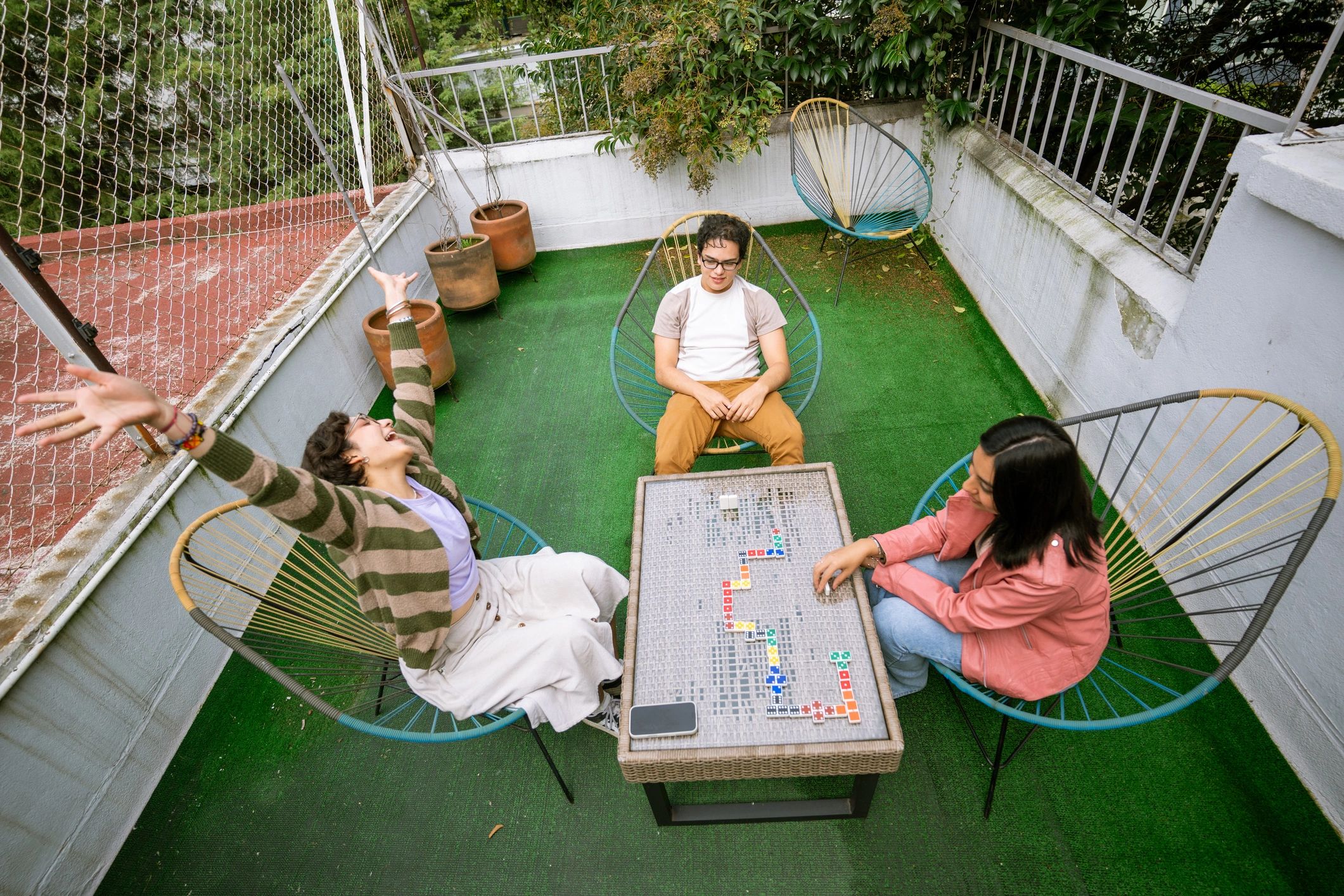 Group playing a tabletop game outdoors around a table