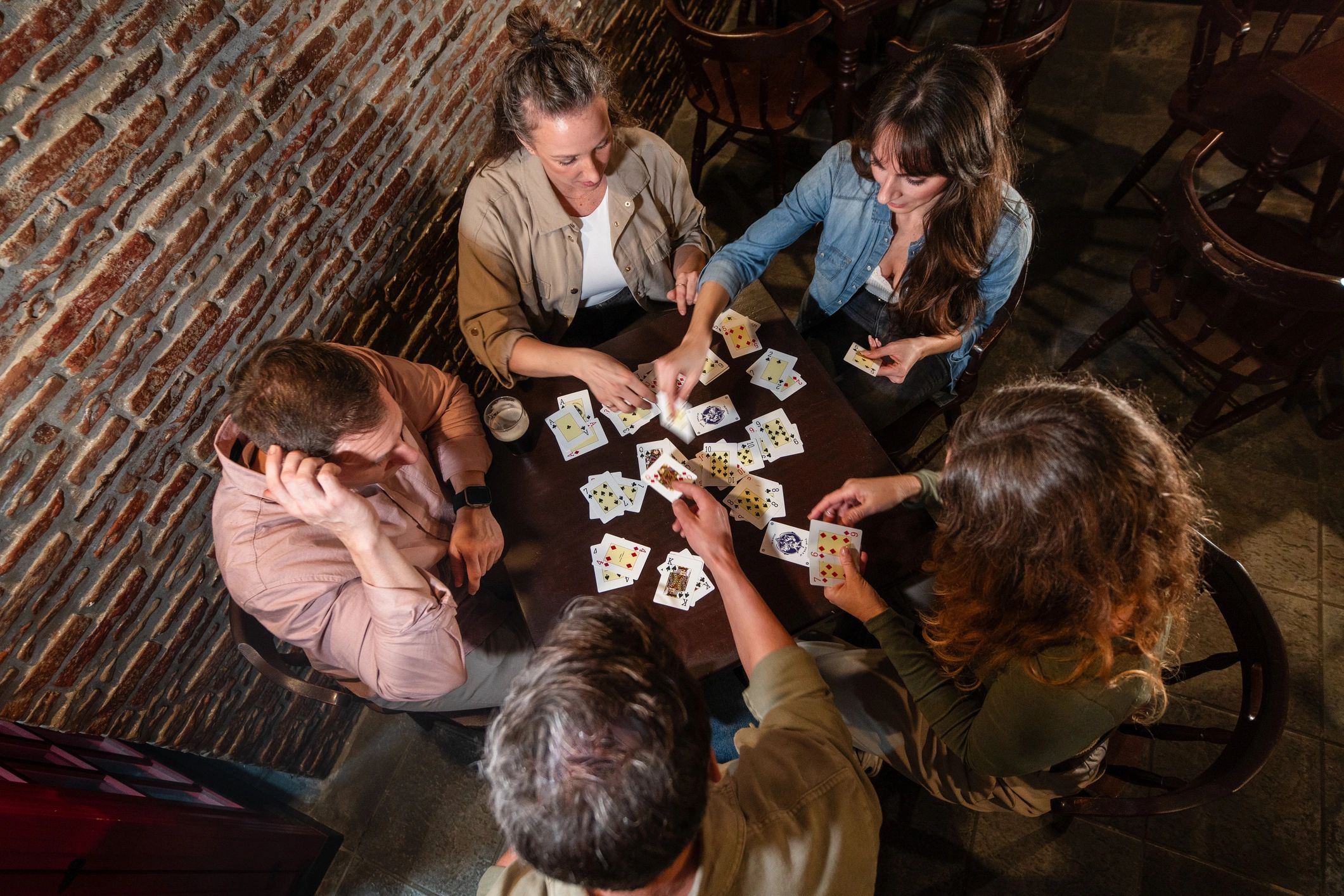 Friends gathered around a table playing cards